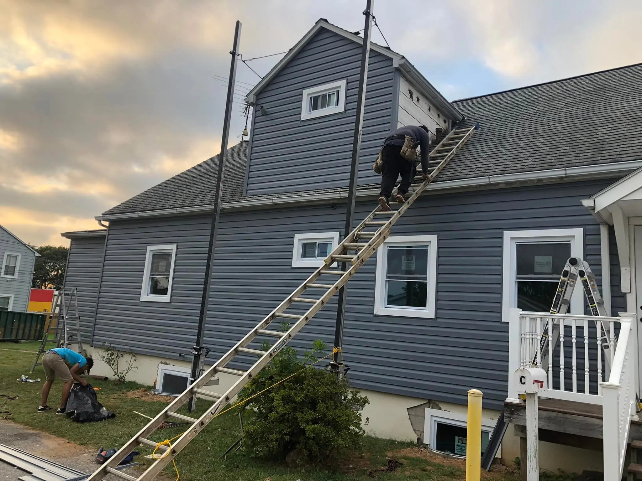 roofing contractor climbing a ladder